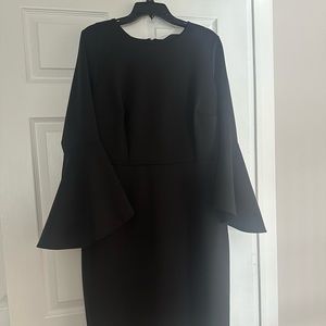 All black scuba A-line dress with fluted sleeves.
